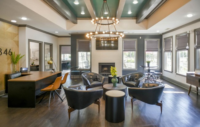 a living room with chairs and a table and a fireplace