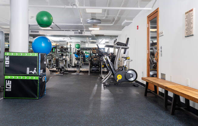 a gym with weights and cardio machines and a wooden table