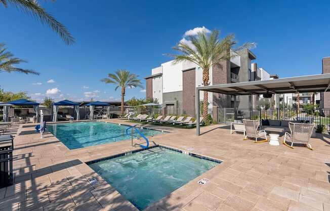 A pool surrounded by chairs and palm trees.