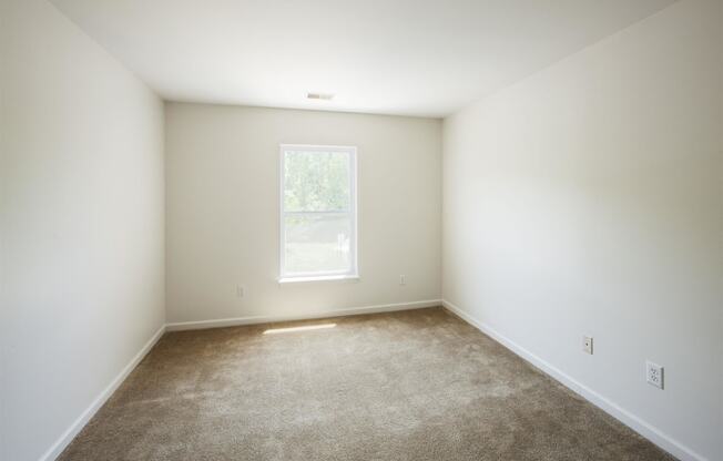 an empty room with carpet and a window