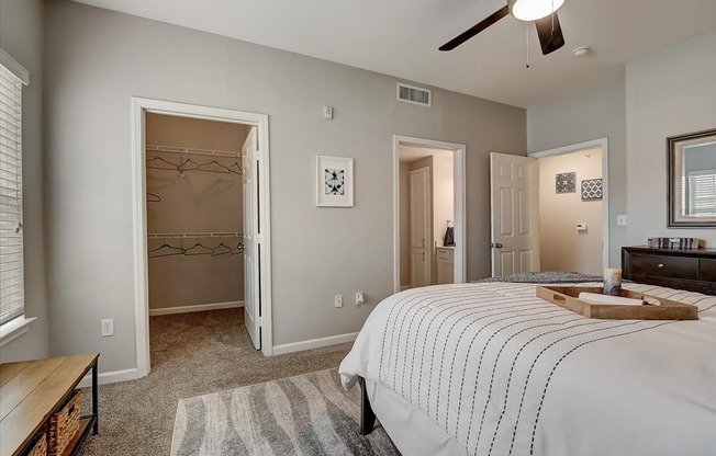 a bedroom with a large bed and a ceiling fan