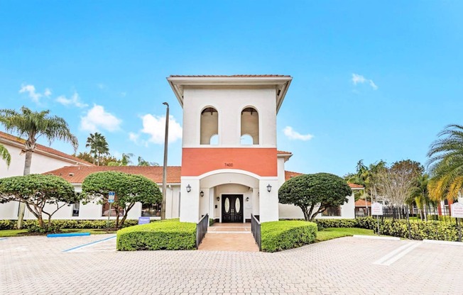 a mansion with a red and white facade and palm trees