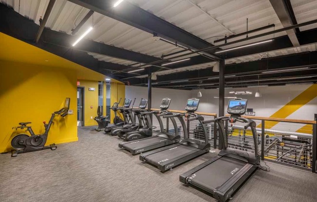 a room filled with lots of cardio equipment and weights