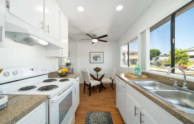 a kitchen with white cabinets and a sink and a window