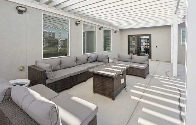 A patio with a white ceiling and grey couches.
