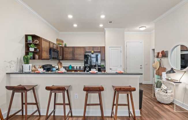 bar stools in front of a kitchen counter with a counter top and a bar