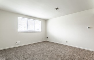 an empty room with carpet and a window