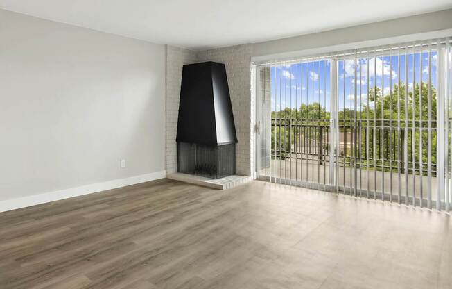 A room with a black speaker and a sliding glass door.