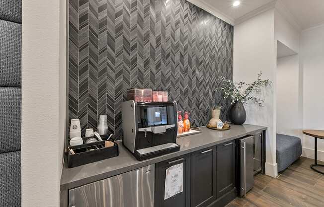 A modern kitchen with a grey countertop and a grey wallpapered backsplash.
