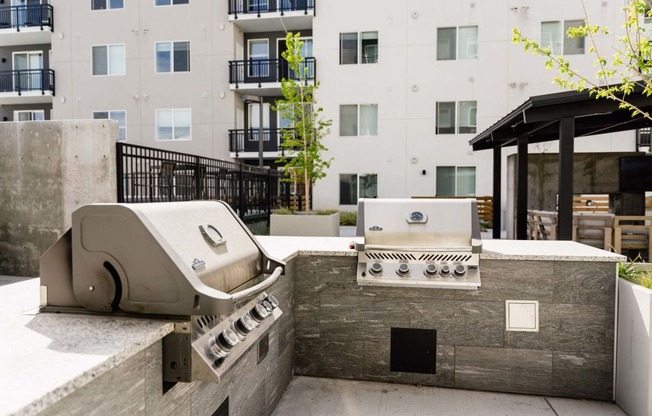 a grill and smoker on the patio of an apartment building