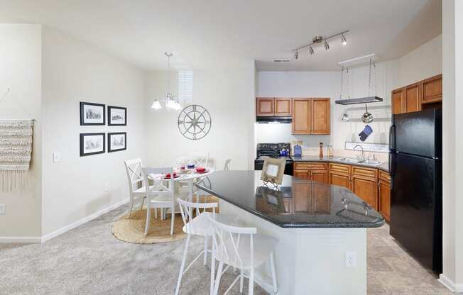 a kitchen with a bar and a dining table with chairs