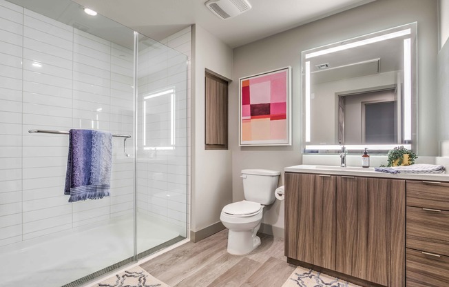 full bathroom with glass doors vinyl wood like flooring at arte apartments