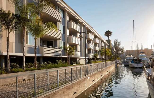 a row of apartment buildings overlooking a waterway with boats