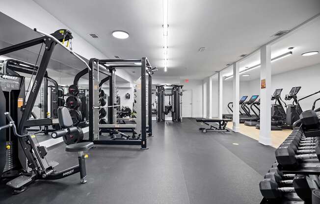 A gym with a variety of equipment including weight machines and free weights.