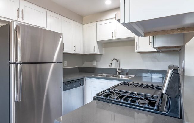 a kitchen with stainless steel appliances and white cabinets