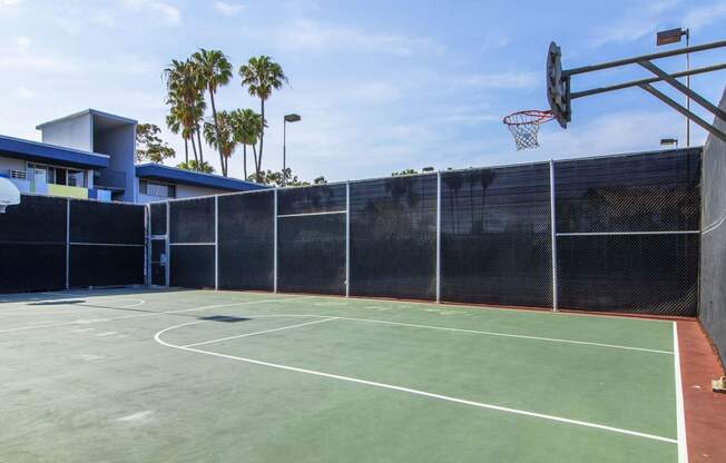 a tennis court with a basketball hoop