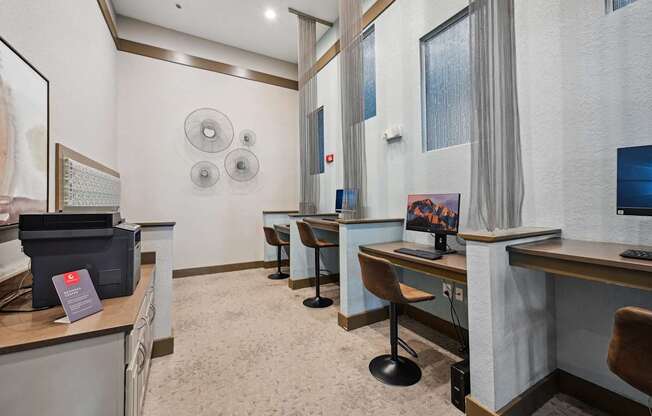 a computer room with desks and chairs and a television