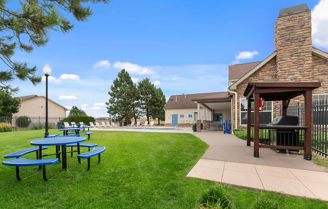 a patio with picnic tables and a pool in the backyard of a house