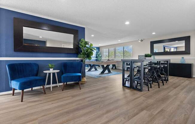 A living room with blue chairs and a wooden floor.