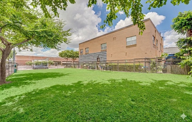 Courtyard with green lawn and mature trees at Vue Live Oak Apartments, Dallas
