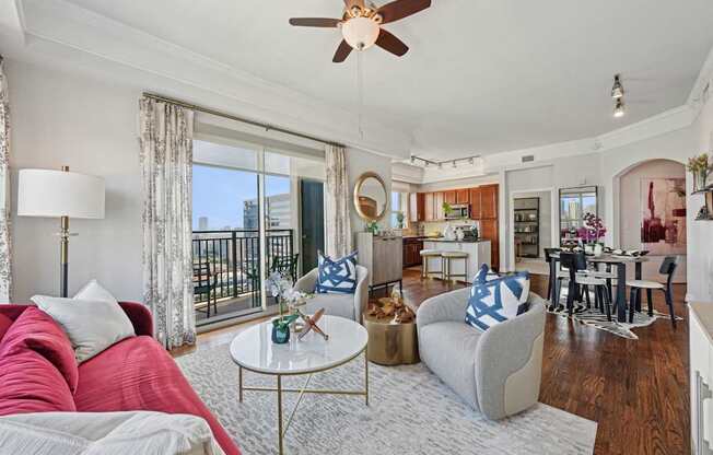 Model apartment living room with a red couch and a white coffee table at Dominion Post Oak apartments in Houston, TX