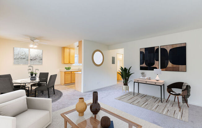A living room with a white couch, a coffee table, and a painting on the wall.