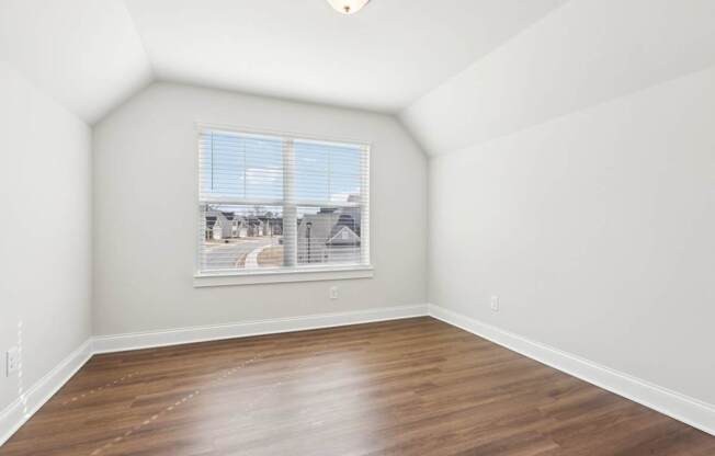 Empty room with a window overlooking a street.