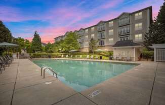 a swimming pool with an apartment building in the background