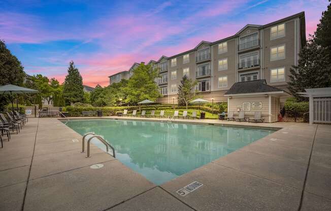 a swimming pool with an apartment building in the background