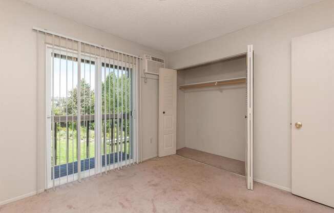 a bedroom with a sliding glass door leading to a balcony at Lincoln Village Apartments, Spokane, 99208