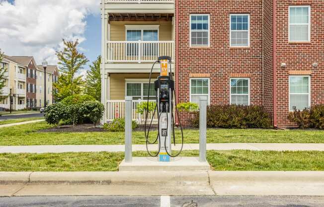 a gas pump sitting in front of a red brick building