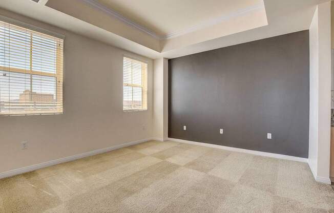 A room with a carpeted floor and a window with blinds.