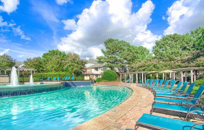 Enclave at Wolfchase Apartments in Cordova Tennessee photo of a resort style pool with chaise lounge chairs and a fountain