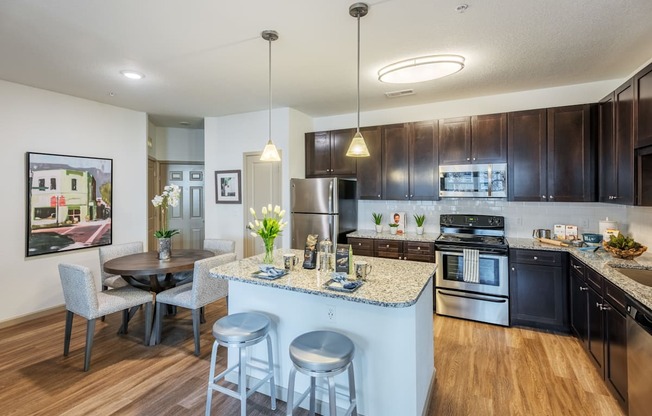 a kitchen and dining area with a granite counter top and stainless steel appliances