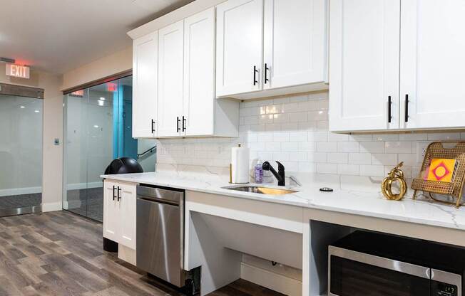 a kitchen with white cabinets and a sink and a dishwasher