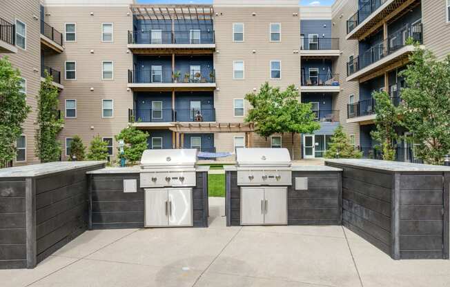 an outdoor view of two grills in front of The Vue apartments
