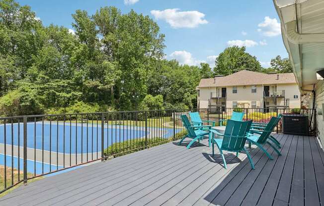 A deck with a table and chairs overlooking a basketball court at Gwinnett Square Apartments in Duluth, GA