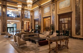 a large lobby with couches and chairs and a table  at The Belden Stratford, Illinois