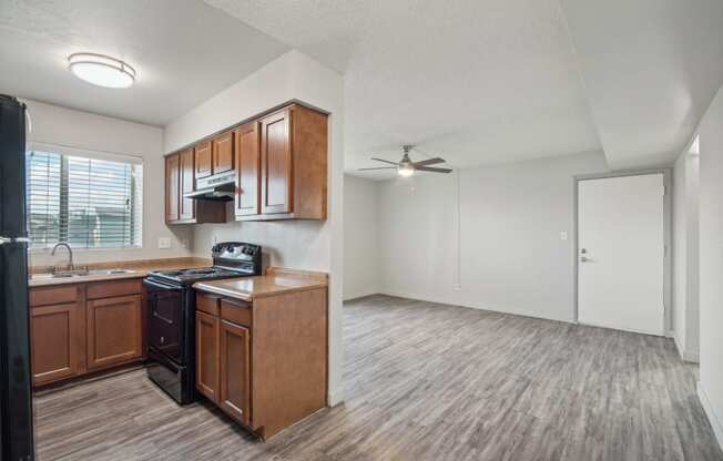 an empty kitchen and living room with a ceiling fan