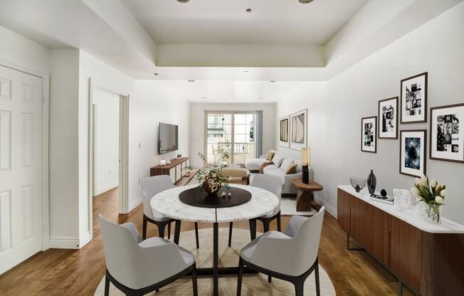 a living room with a round table and white chairs