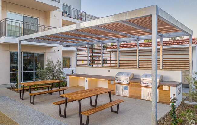 A patio with a table and chairs under a roof.