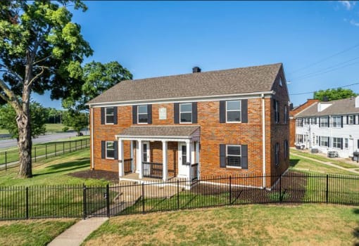 a brick townhouse with a black fence