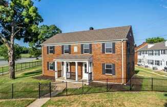 a brick townhouse with a black fence