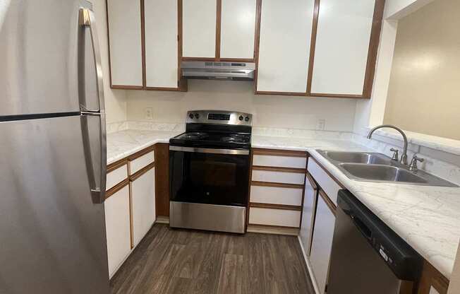 A kitchen with a stove, refrigerator, and cabinets.