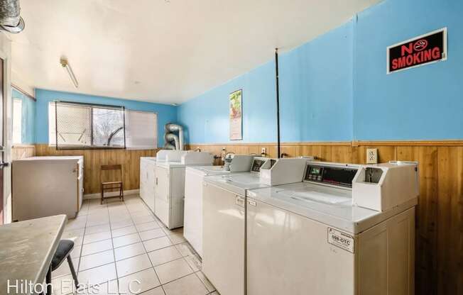 a laundry room with several washes and dryers in it