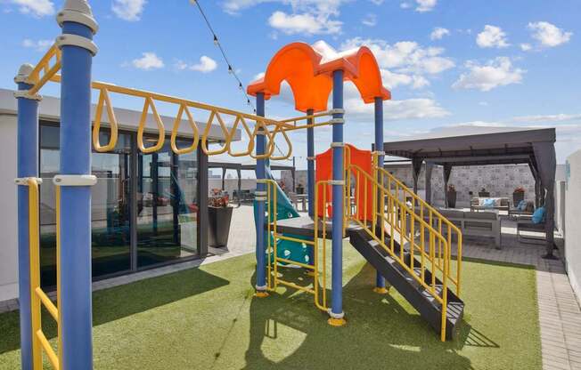 A playground with a slide and a climbing frame.