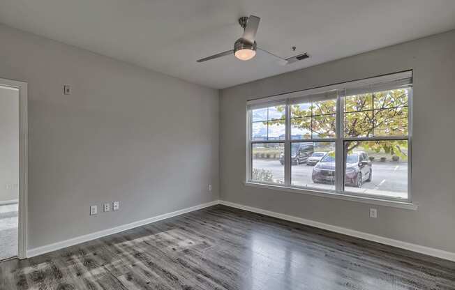 an empty living room with a large window and a car parked outside at Nexus at Sandhill, Columbia South Carolina