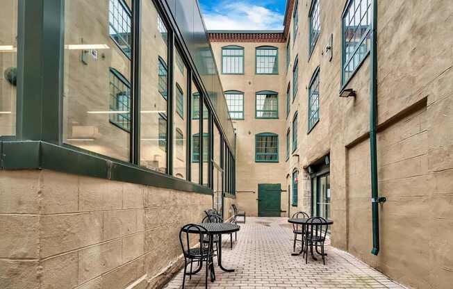 A narrow alley with tables and chairs on either side.