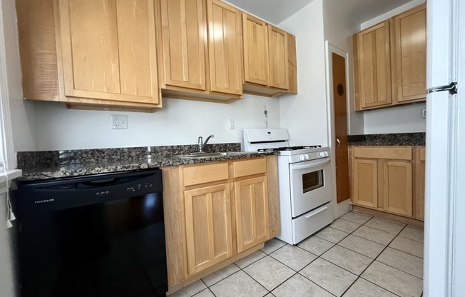 A kitchen with maple cabinets and tile floors