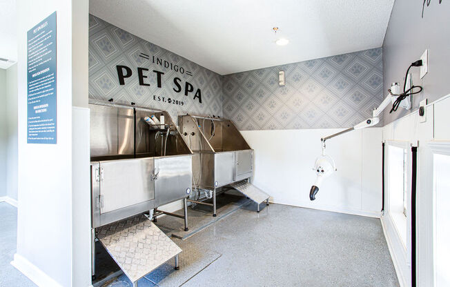 a pet spa room with a large stainless steel machine and a shower